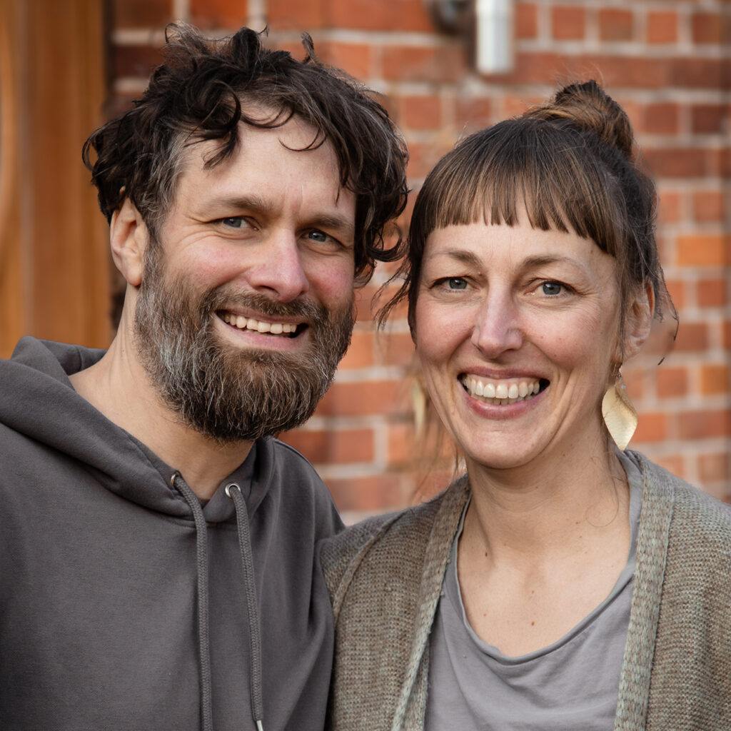 Portrait von einem Mann und einer Frau vor einer Backsteinmauer